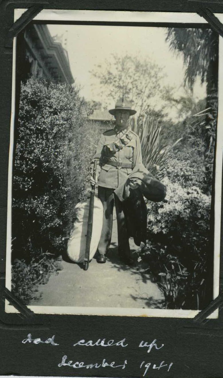 Walter in uniform, rifle, kitbag and greatcoat, with the album caption Dad called up December 1941